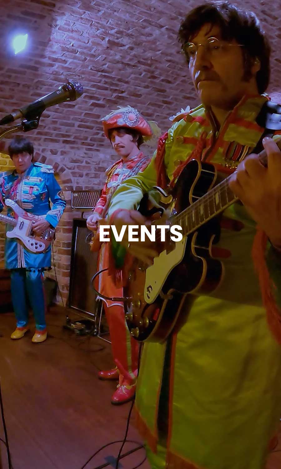 American English Beatles tribute band performing live on stage at Let It Be in Waukesha, Wisconsin, with lighting and instruments under a concert setting.