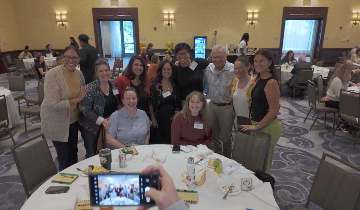 Candid group of speakers capturing a phone selfie at the AB Korkor Foundation’s Motion Impacts Emotion 2025 Conference at the Marriott West in Pewaukee, Wisconsin, highlighting the joy and connection in a professionally captured event video production setting.